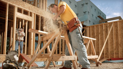 Man using portable generator to power hand saw at a jobsite